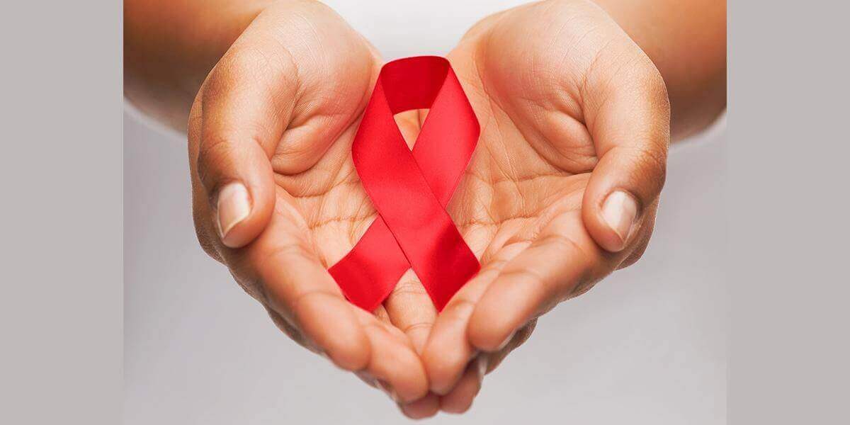 Hands holding red HIV/Aids awareness ribbon
